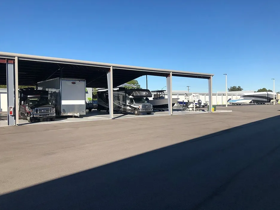 View of covered RV and boat parking at Elite Motorcoach Storage.