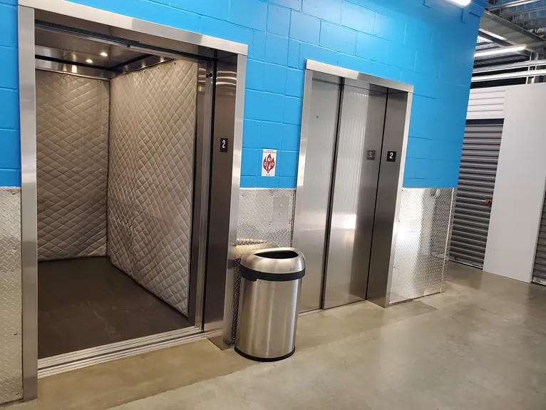 Interior hallway with freight elevators and overhead lighting at Storage Lounge.