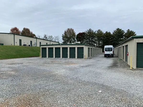 Rows of storage units with gravel surface at Volunteer Storage Tellico Village.