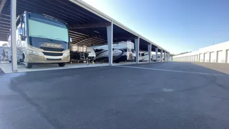 View of covered RV and boat parking at Elite Motorcoach Storage.