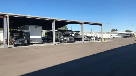 View of covered RV and boat parking at Elite Motorcoach Storage.