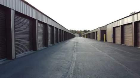 Storage building row with multiple unit doors and gravel drive at Lambertville Mini Storage Secor.