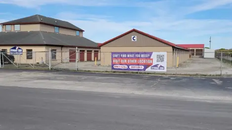 Exterior View of Storage Crib facility with fenced perimeter and drive-up units.