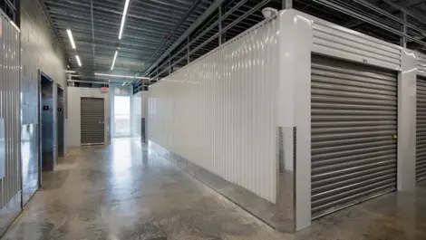 Bright corridor with clean roll-up doors at Storage Lounge.