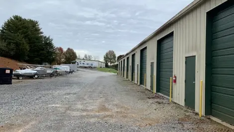 Wide-angle View of storage unit buildings and open gravel lot at Volunteer Storage Tellico Village.