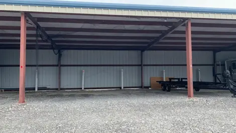 Fenced vehicle storage lot with gravel surface at Volunteer Storage Vonore.