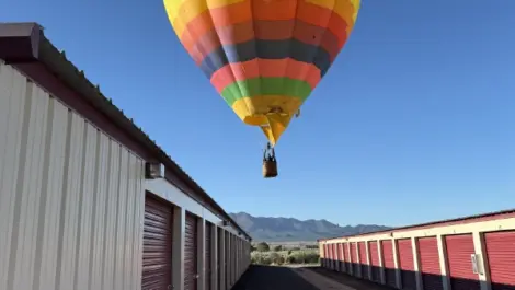 Colorful hot air balloon above Alices Attic Self Storage on beautiful sunny day