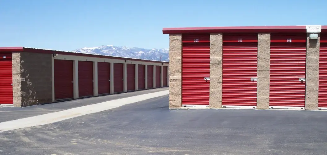 Outdoor drive up access storage units at Alice's Attic Self Storage with mountains in the background.