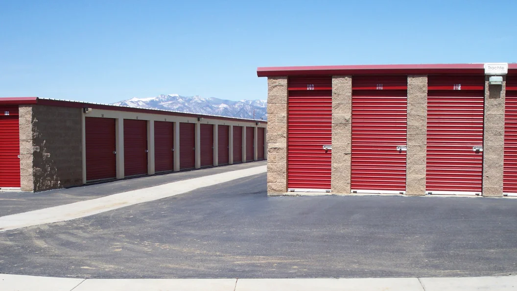 Outdoor drive up access storage units at Alice's Attic Self Storage with mountains in the background.