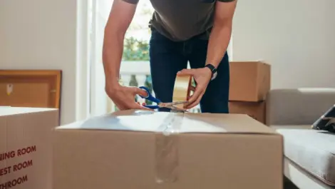 White man taping box closed